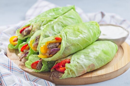Cabbage leaves wraps with beef, vegetables and cheese, served with plain yogurt, horizontal