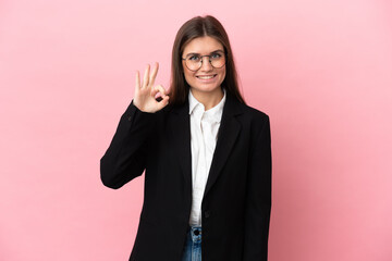 Young Business caucasian woman isolated on pink background showing ok sign with fingers