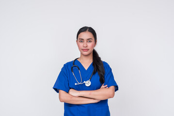 Confident young Asian female caregiver in blue scrub suit, standing against a white background