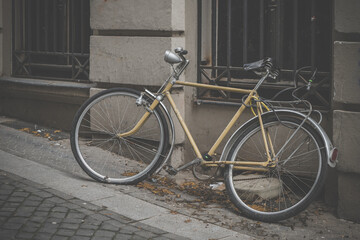 an old bicycle on the sidewalk in front of a house