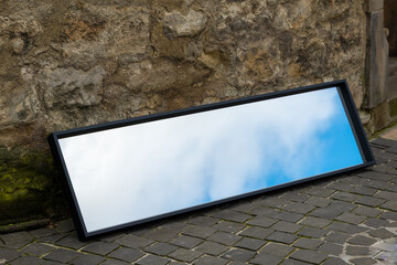 a mirror on a wall that shows the sky