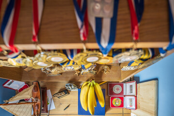Fresh ripe banana fruit on bedroom shelf with sport award on background