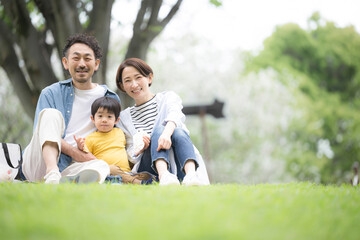 Fototapeta premium 公園でピクニックをする家族 春夏のお出かけやレジャーのイメージ