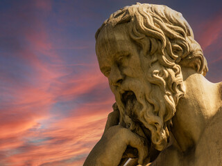 Socrates bust marble statue, the ancient Greek philosopher, under a fiery sky. Travel to Athens,...