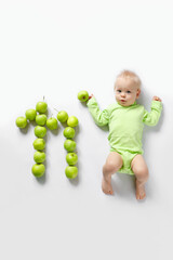 Fototapeta premium eleven month old infant on white background with pineapple