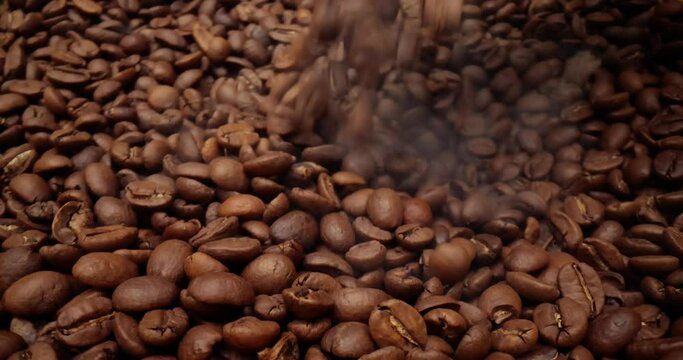 Close up of seeds of coffee. Fragrant coffee beans are roasted smoke comes from coffee beans.