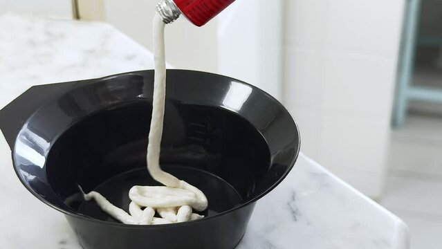 Zubereitung von Haarfarbe in einem Plastikgef&auml;&szlig;