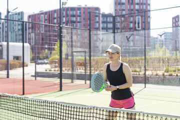 Woman padel tennis player training on court. Woman using racket to hit ball.