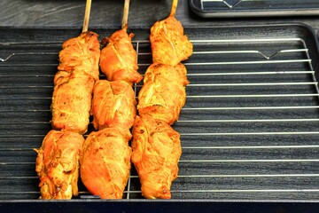 Street food. Skewered, marinated chicken pieces await grilling, showcasing the vibrant, spicy...