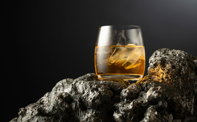 Whiskey with ice on a grey stone.