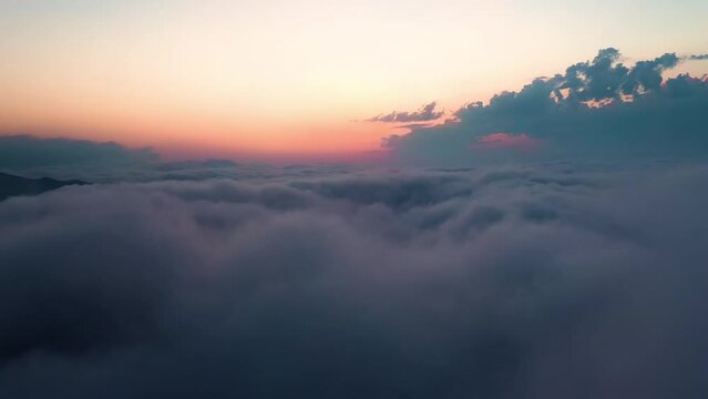 Flying over the clouds with the late sun. Sunrise or sunset colorful sky background.
