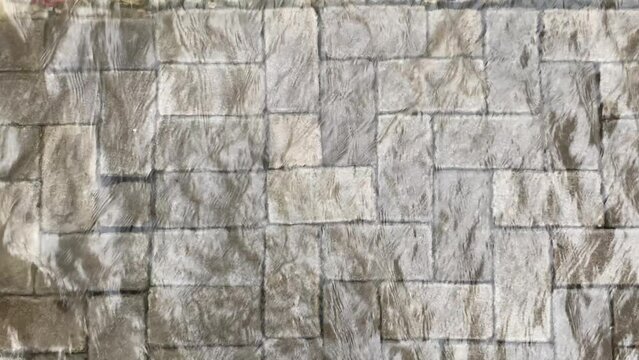 Top view or flat lay view of shallow water flow on grey paved background