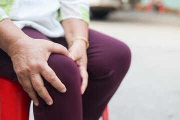 close up senior woman sit and hand massage on knee for relief symptom in home for mature healthy lifestyle concept