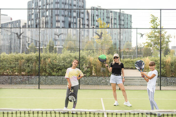 mother and daughters playing padel outdoor