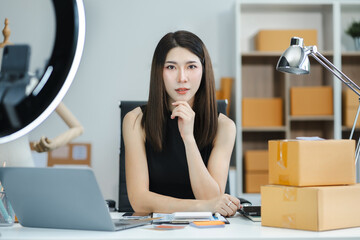 Female asian sitting at the desk, looking to camera.Happy woman, entrepreneur, small business owner...
