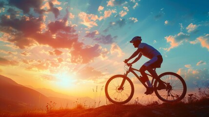 Fototapeta premium A man is riding a bicycle on a hill with a beautiful sunset in the background