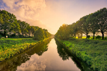 Sunset light and reflections in the water of the Wilhelminakanaal canal near village of...