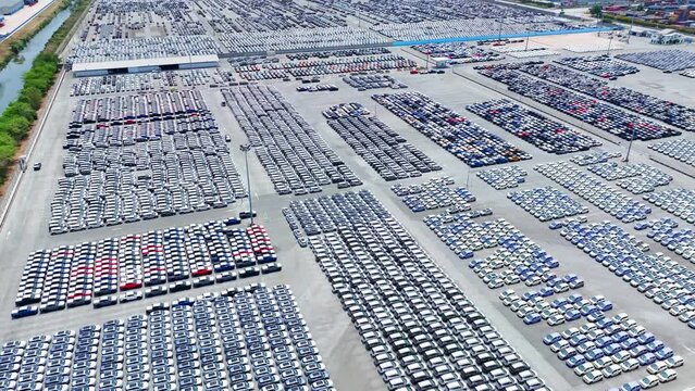 An aerial snapshot reveals a vast parking lot, cars meticulously aligned like pieces on a chessboard, forming a symphony of order amidst the asphalt canvas.
