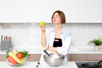 Young attractive fit woman cooking in the kitchen. Cooking healthy food concept	