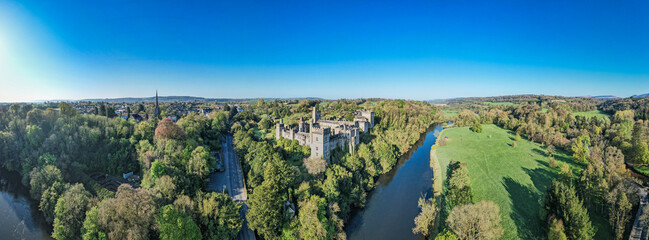 An aerial panorama reveals the majestic Lismore Castle in County Waterford, Ireland, set against a...