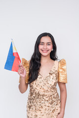 Proud Filipino woman in traditional Filipiniana dress holding the Philippine flag, isolated on white