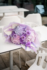 Large bouquet of various purple flowers lies on a white table