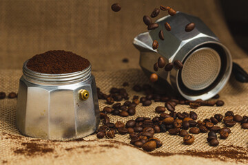 Moka pot and coffee grinder on natural burlap dark background. Coffee making concept.