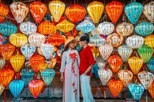 Asian Couple wearing vietnam  traditional culture  choosing lanterns  at Hoi An ancient town,Hoi an city in Vietnam.