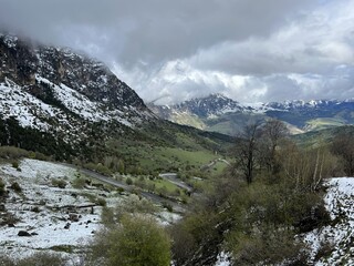Tseylomsky pass in Ingushetia. A trip uphill to the Tsei Loam pass on a cloudy spring day. Panorama of the high cliffs of the Dzheyrakh gorge. North Caucasus, Russia