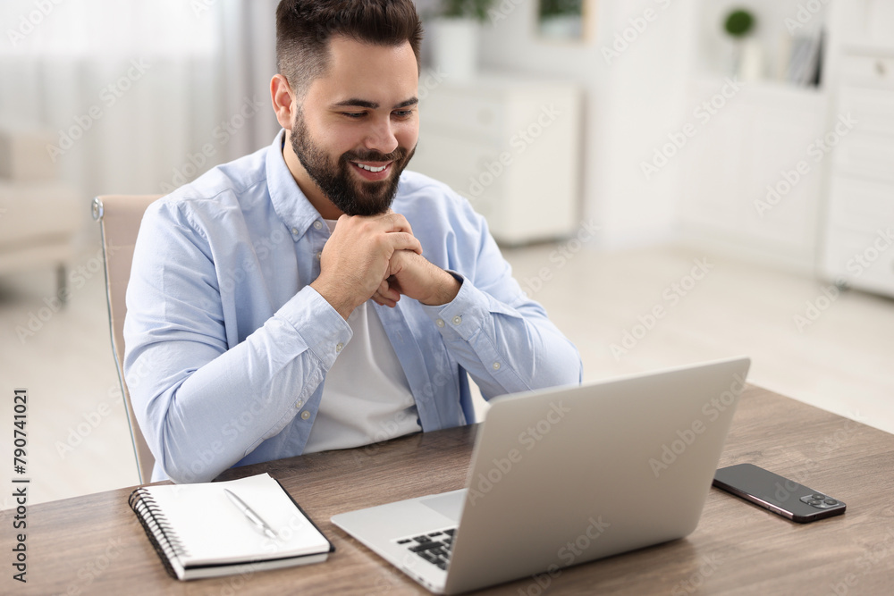 Sticker Young man watching webinar at table in room