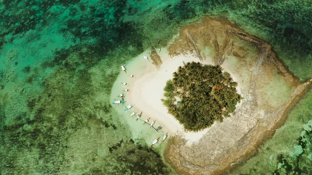 Tropical island in the ocean with palm trees on white sand beach. Guyam island, Philippines, Siargao. Summer and travel vacation concept