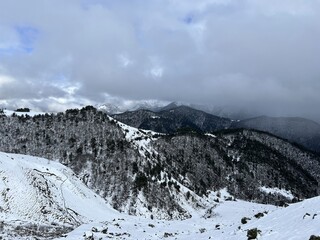 Tseylomsky pass in Ingushetia. A trip uphill to the Tsei Loam pass on a cloudy spring day. Panorama of the high cliffs of the Dzheyrakh gorge. North Caucasus, Russia