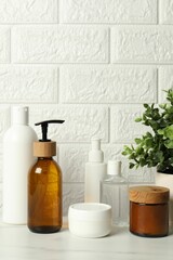 Bath accessories. Personal care products on white table near brick wall