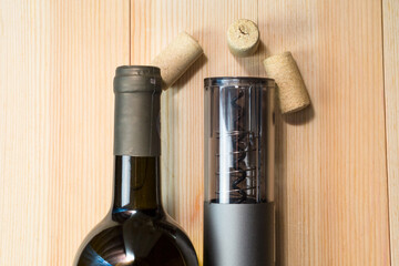 Device for automatic opening wine bottles, electric corkscrew on light table.