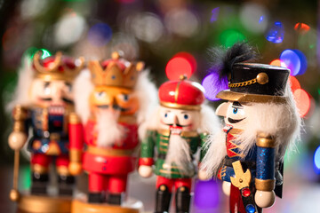 A group of nutcrackers are standing in a row, with one of them wearing a red hat