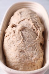 Fresh sourdough in proofing basket on table, closeup