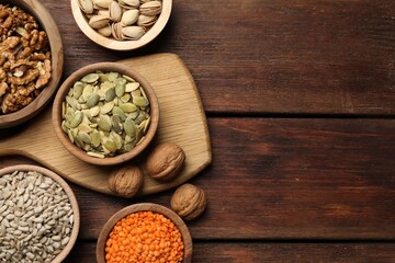 Different products high in vegetable fats on wooden table, flat lay. Space for text