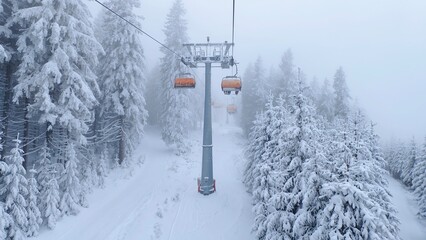 The snow-covered piste for skiers and snowboarders is laid out among snow-covered spruce trees....