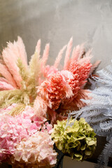 Close-up of sprigs of artificial pink and blue fern, green and pink hydrangea and other decorative sprigs
