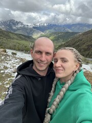 A man with a woman on the background of the Ceylomsky pass in Ingushetia. A trip uphill to the Tsei...