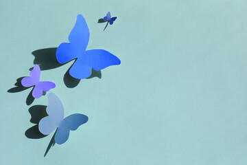 Colorful bright paper butterflies on light blue wall