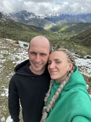 A man with a woman on the background of the Ceylomsky pass in Ingushetia. A trip uphill to the Tsei...
