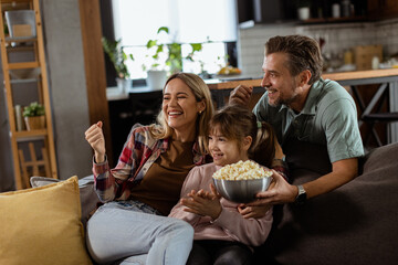 Family Movie Night: Engrossed in Thrilling Scenes at Home