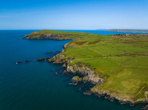 Aerial shot travelling along rocky coastline and cliffs of West Wales near Fishguard on windy but sunny day