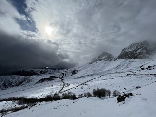 Tseylomsky pass in Ingushetia. A trip uphill to the Tsei Loam pass on a cloudy spring day. Panorama of the high cliffs of the Dzheyrakh gorge. North Caucasus, Russia