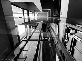 Glass elevator in the building, monochrome. Construction glazed internal elevator to the sky, urban architecture. Background.