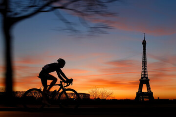 Silhouette of a cyclist at sunset with the Eiffel Tower in the background
