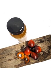 palm fruit and a bottle of edible oil on a white background