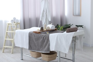 Rolled towel and spa products on massage table in recreational center