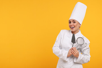 Happy confectioner in uniform holding professional tools on yellow background. Space for text